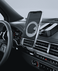 The foldable phone stand being used as a car air vent mount, securely holding a smartphone vertically on the dashboard of a luxury vehicle for hands-free navigation.